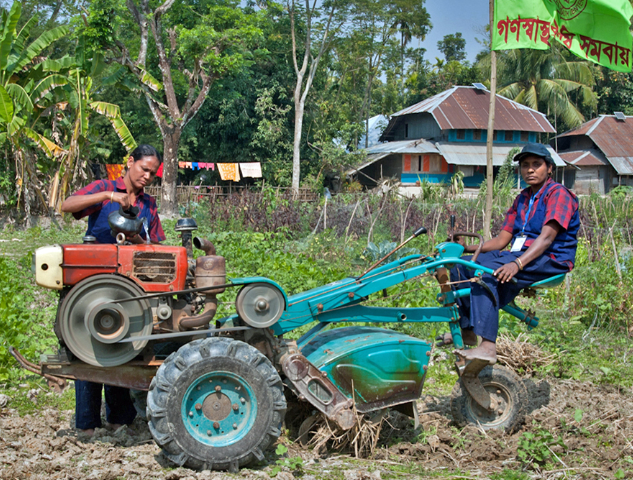 deux femmes Bangladaises s'occupant des champs sur leur tracteur